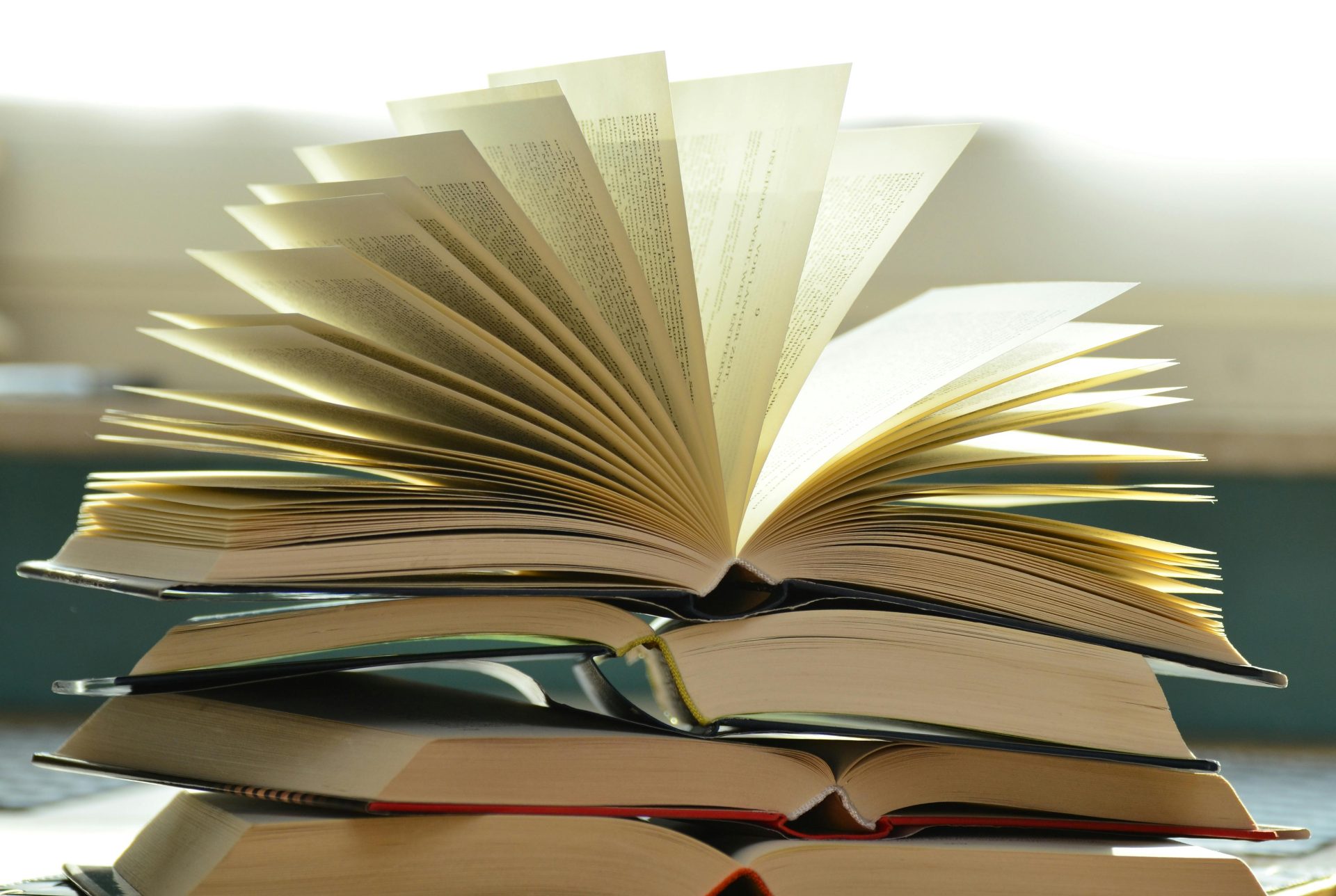 Gros plan d'une pile de livres ouverts avec des pages déployées, capturant une atmosphère d'étude.